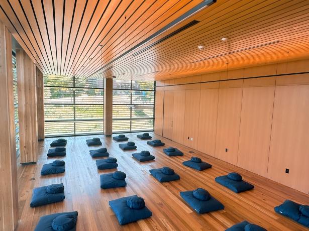 Empty cushions in rows placed in rows inside a Contemplative Commons classroom. 